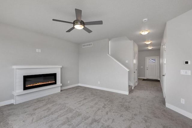 unfurnished living room with ceiling fan and light colored carpet