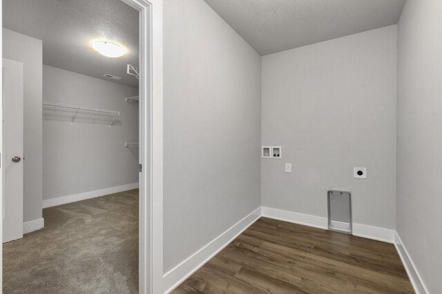 clothes washing area featuring dark colored carpet, hookup for a washing machine, a textured ceiling, and electric dryer hookup