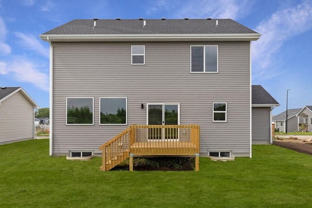 rear view of house featuring a wooden deck and a lawn