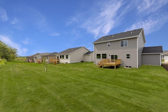 back of property featuring a yard and a wooden deck