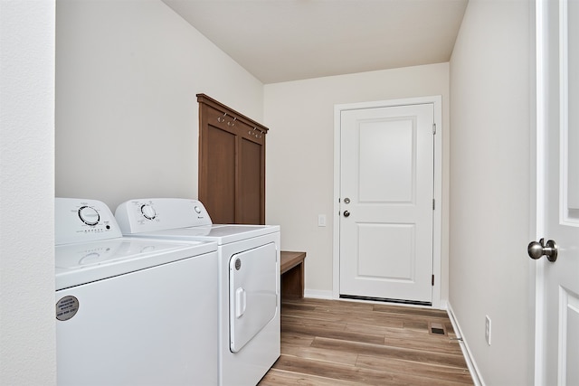 laundry room featuring light wood-type flooring and washer and dryer