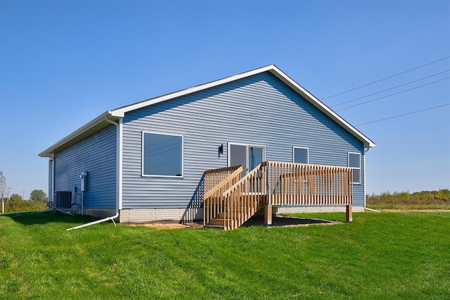 rear view of property featuring a wooden deck, central AC unit, and a yard