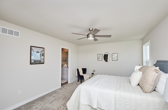 bedroom featuring light colored carpet, ceiling fan, and connected bathroom