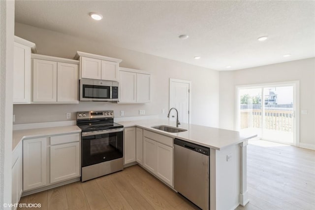 kitchen featuring kitchen peninsula, sink, and appliances with stainless steel finishes