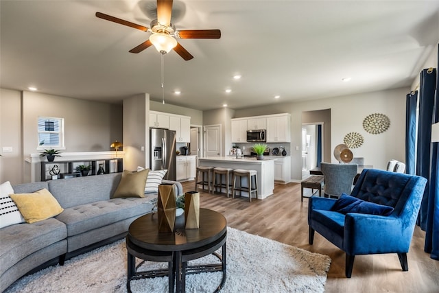 living room featuring recessed lighting, light wood-style floors, and ceiling fan