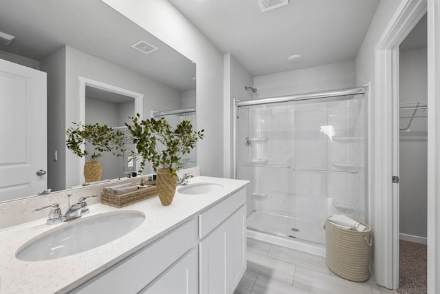 bathroom featuring tile patterned flooring, vanity, and a shower with shower door