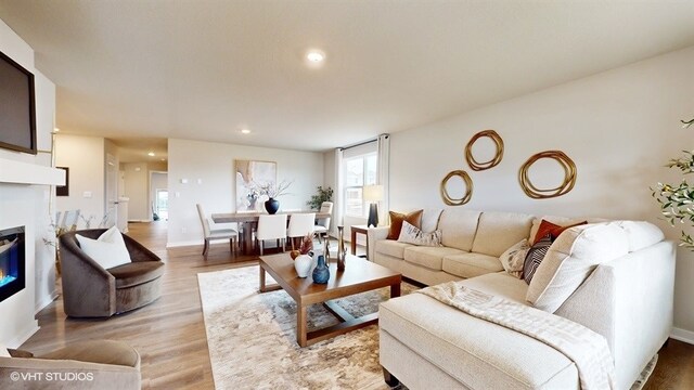 4416 NE 13th St, Ankeny, IA 50021 - living area with light wood-type flooring, baseboards, a glass covered fireplace, and recessed lighting