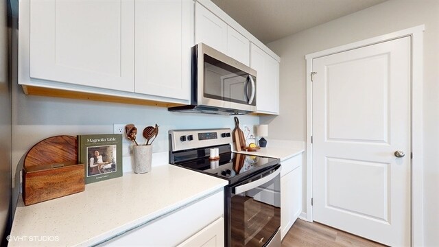 4416 NE 13th St, Ankeny, IA 50021 - kitchen with white cabinets, stainless steel appliances, and light wood finished floors