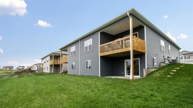 rear view of house with a balcony and a yard