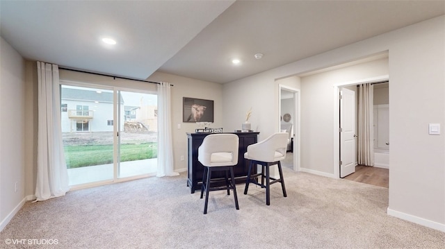 carpeted dining area with indoor bar