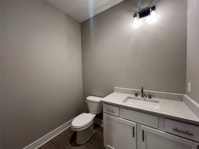 bathroom with hardwood / wood-style floors, vanity, and toilet