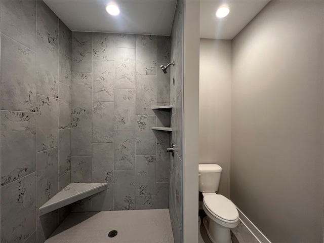 bathroom with toilet and a tile shower