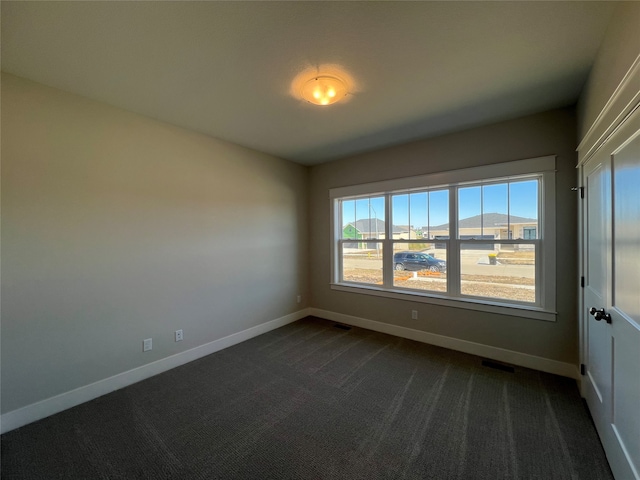 empty room with a mountain view and dark carpet