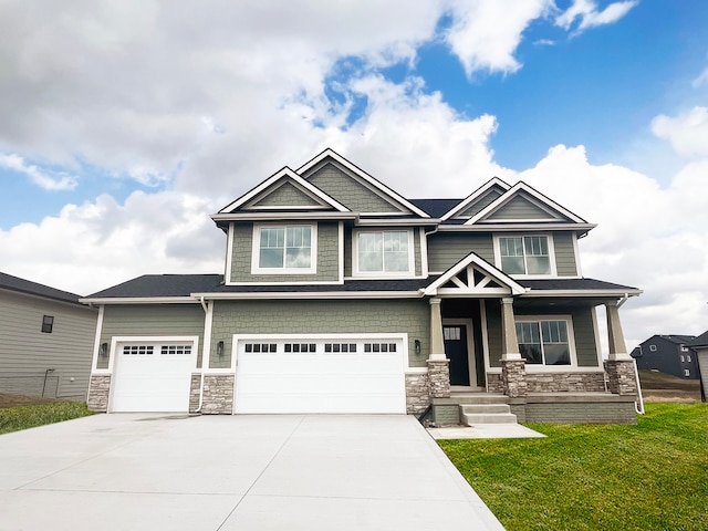 craftsman-style home featuring a garage, a front yard, and a porch