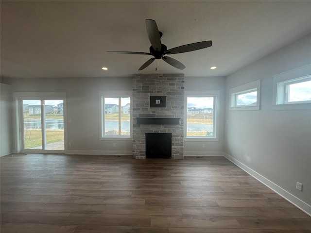 unfurnished living room featuring ceiling fan, dark hardwood / wood-style floors, and a fireplace