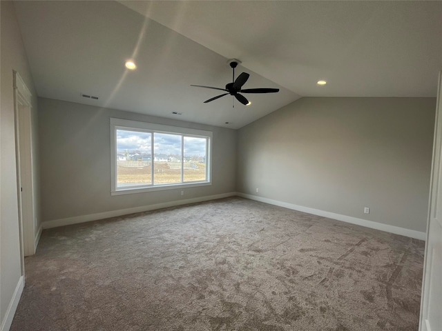 empty room with lofted ceiling, ceiling fan, and carpet floors