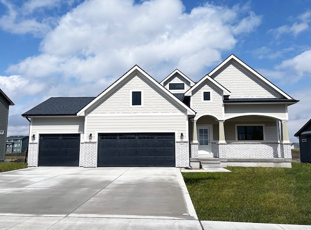 craftsman-style house featuring a garage, a porch, and a front lawn