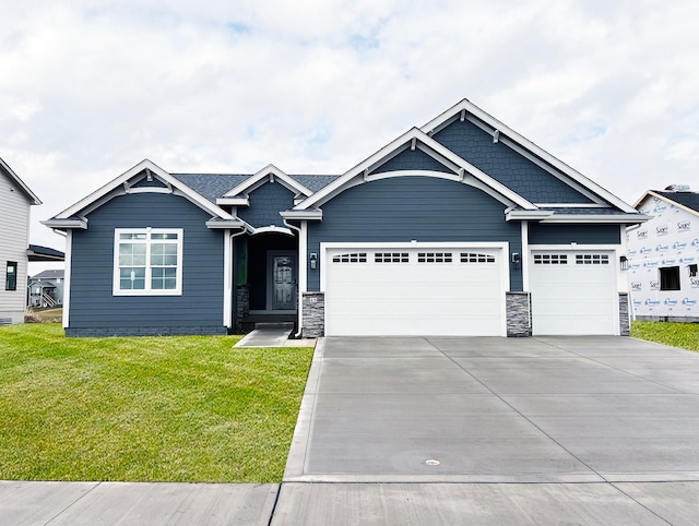 craftsman-style house featuring a garage and a front yard