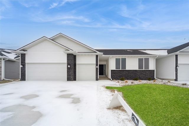 ranch-style house with a garage and a front lawn