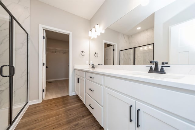 bathroom with hardwood / wood-style flooring, an enclosed shower, and vanity