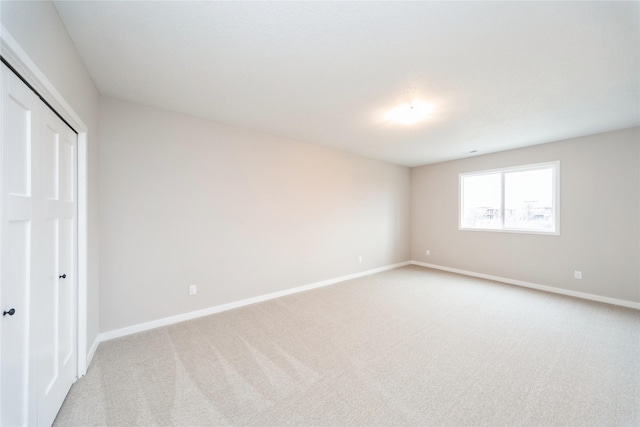 unfurnished bedroom with light carpet and a closet