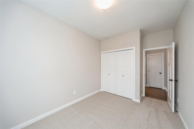 unfurnished bedroom featuring light colored carpet and a closet