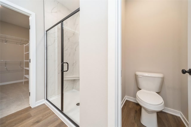 bathroom with hardwood / wood-style floors, toilet, and walk in shower