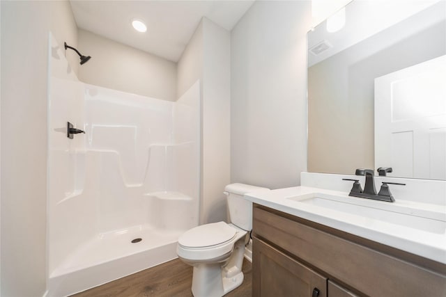 bathroom with a shower, hardwood / wood-style floors, toilet, and vanity