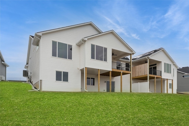 back of house with a balcony, a yard, and ceiling fan