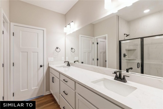 bathroom with hardwood / wood-style flooring, vanity, and a shower with shower door