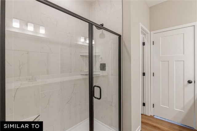 bathroom featuring hardwood / wood-style floors and a shower with shower door