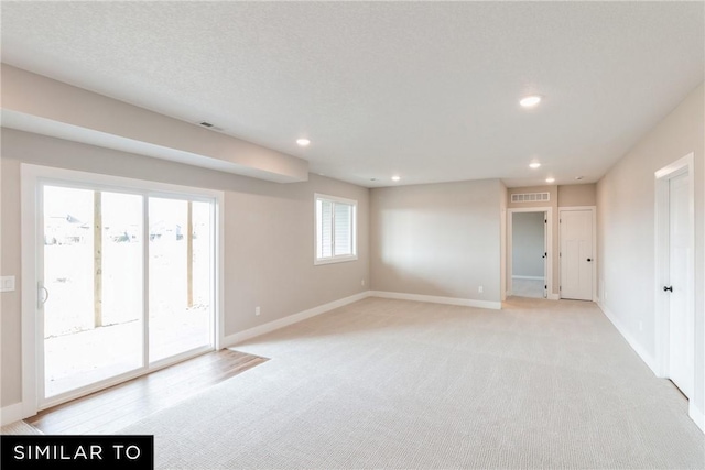 carpeted empty room with a textured ceiling