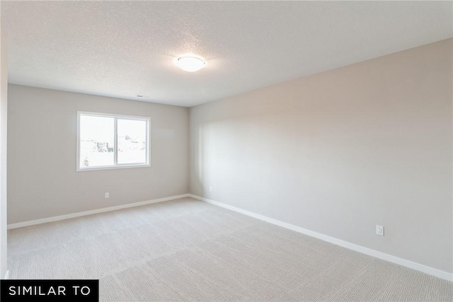 carpeted spare room featuring a textured ceiling