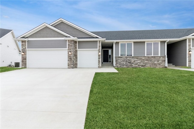 view of front of house with a garage, central air condition unit, and a front yard