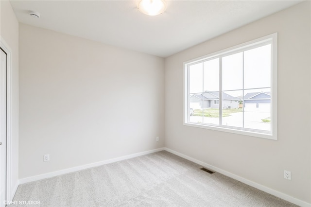 spare room featuring light carpet