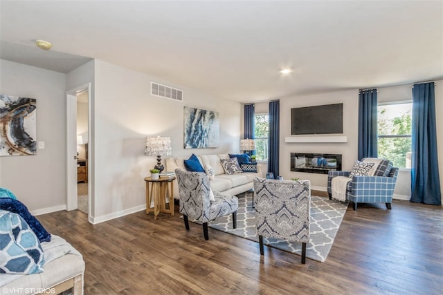 living room featuring dark hardwood / wood-style floors and a healthy amount of sunlight