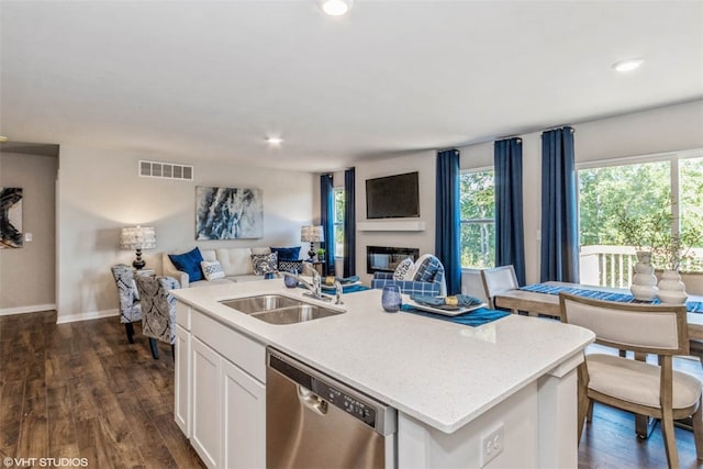 kitchen with sink, plenty of natural light, stainless steel dishwasher, dark wood-type flooring, and white cabinetry