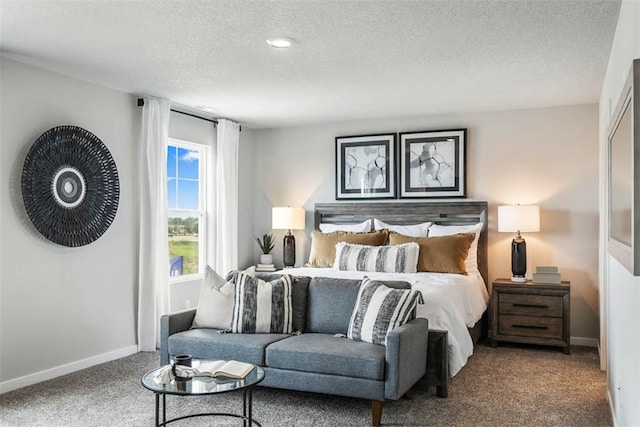 bedroom featuring a textured ceiling and dark colored carpet