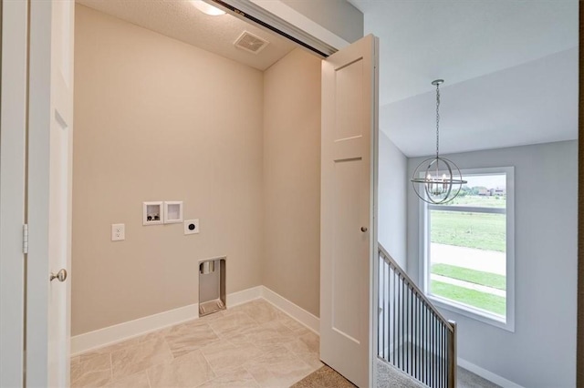 washroom with hookup for an electric dryer, a wealth of natural light, hookup for a washing machine, and an inviting chandelier