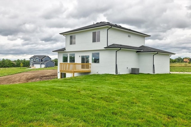 back of house featuring central AC unit and a lawn