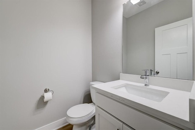 bathroom with hardwood / wood-style floors, vanity, and toilet