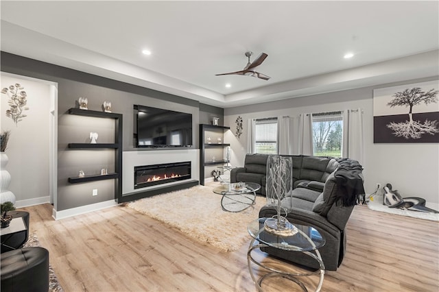 living room with ceiling fan and light hardwood / wood-style flooring