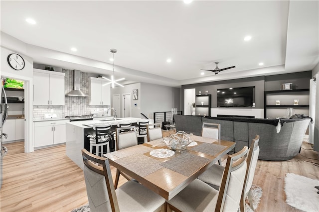 dining room with ceiling fan, light hardwood / wood-style flooring, and sink