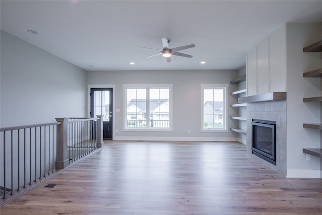 unfurnished living room with light hardwood / wood-style flooring, a fireplace, and ceiling fan