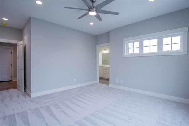 unfurnished bedroom with ceiling fan, light carpet, and ensuite bathroom