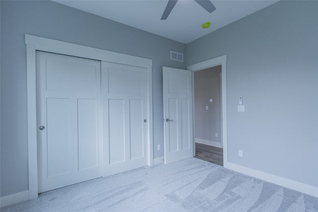 unfurnished bedroom featuring a closet, ceiling fan, and light colored carpet