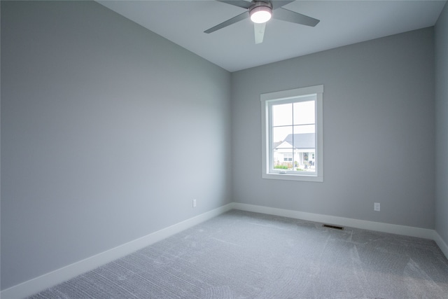 carpeted spare room featuring ceiling fan