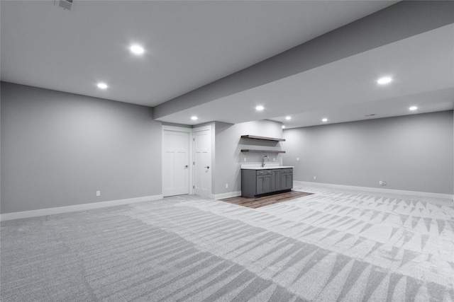 basement featuring indoor wet bar and light colored carpet