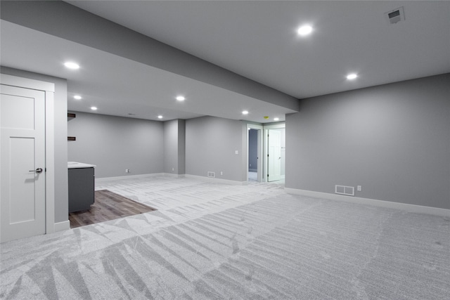 basement featuring light carpet