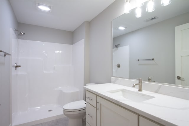 bathroom with vanity, toilet, a shower, and tile patterned flooring